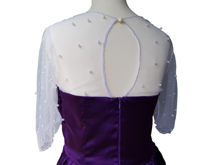 Oberteil von lila Kleid trapiert und mit weißen Spitzenstoff und Perlen - Rückenseite